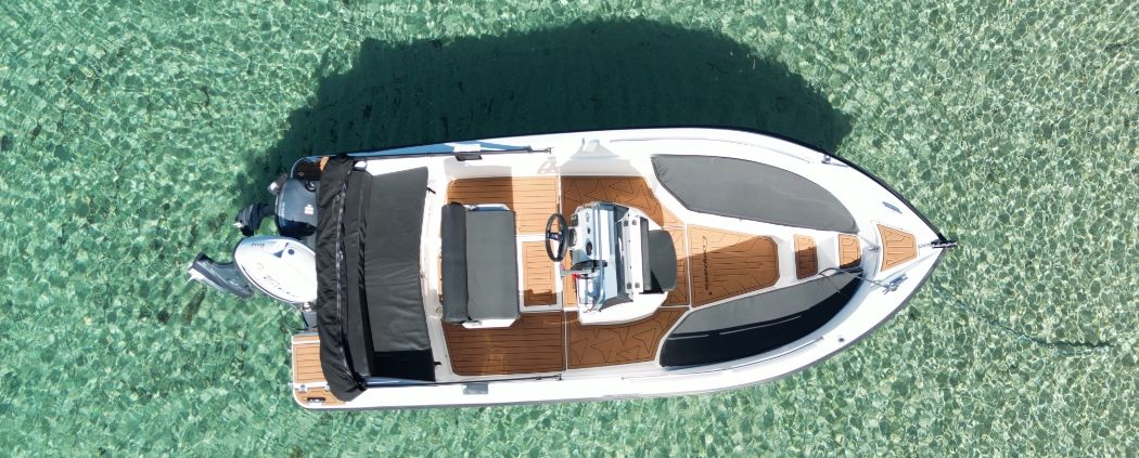 Rental boat seen from above on turquoise water – Boat4You